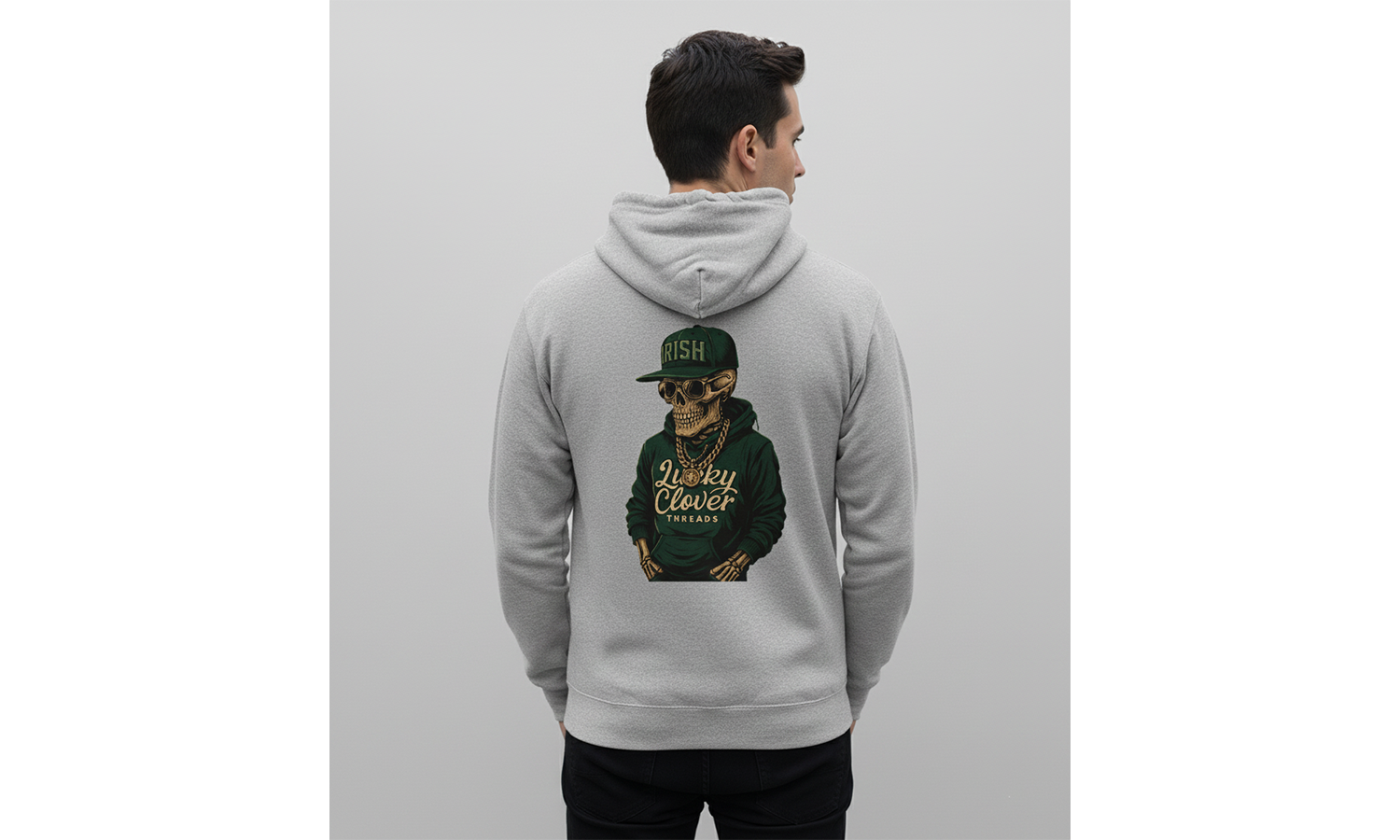 Person wearing a gray hoodie with a graphic of a person in a green cap on the back, against a light gray background