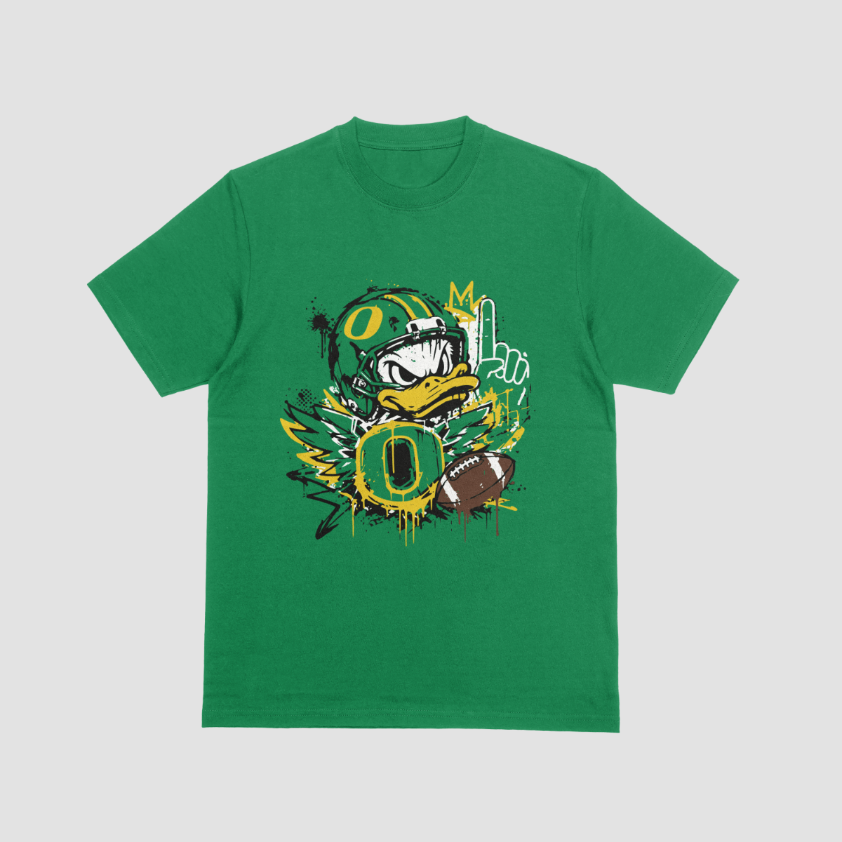 A green short-sleeve crewneck t-shirt featuring a graphic print of the Oregon Ducks football mascot, a duck wearing a helmet with the number 0, alongside a football, a cactus, and paint splatter details on a light gray background.